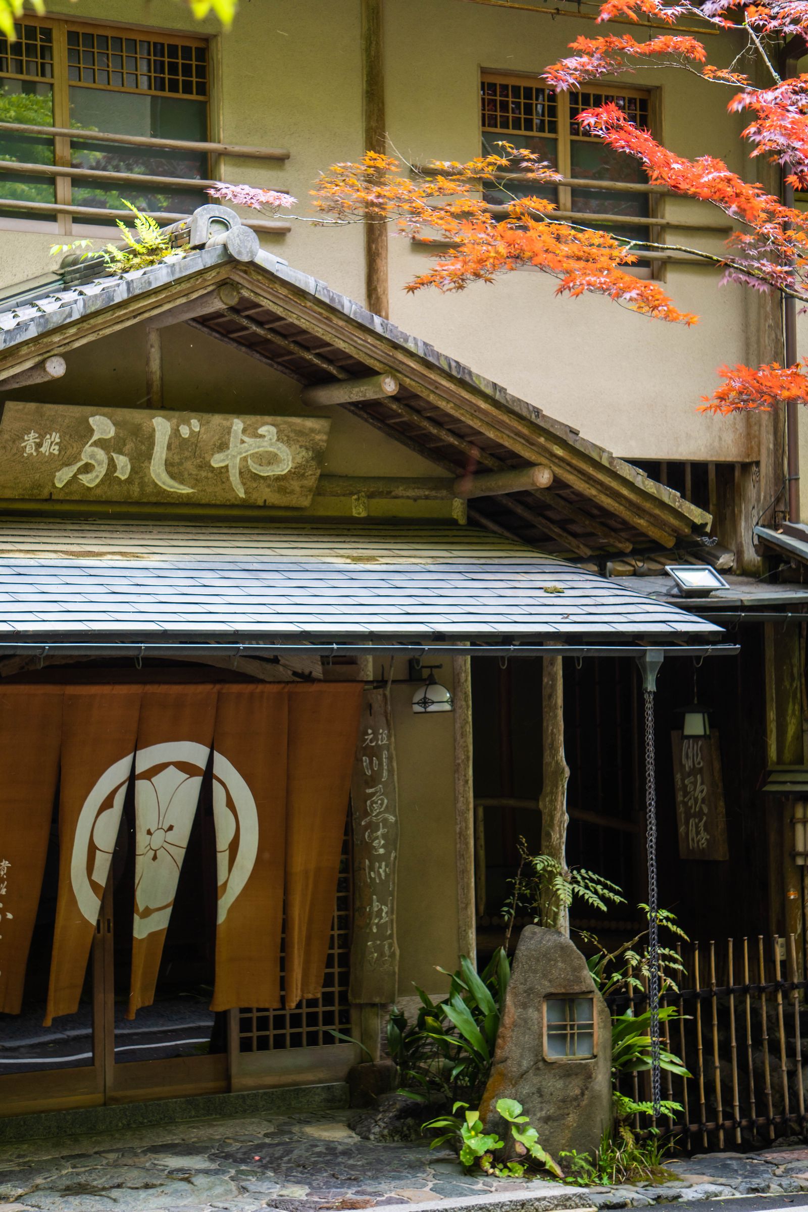 秋の葉に包まれた旅館の外観